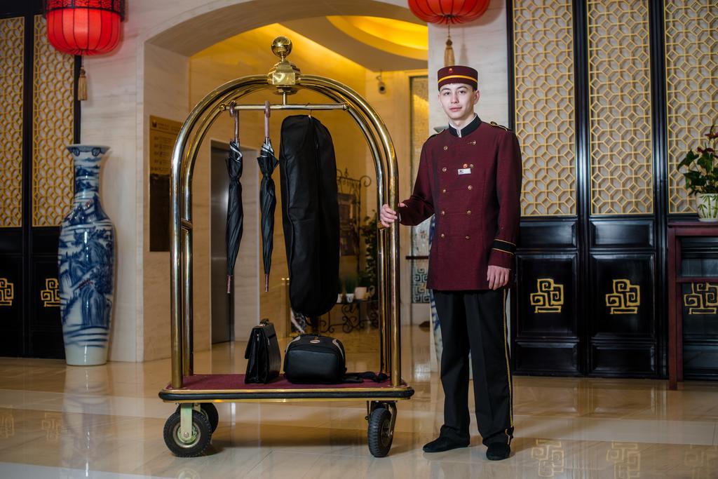 Beijing Palace Soluxe Hotel Astana Buitenkant foto A bellboy with a luggage cart